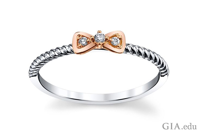 Кольцо из 10-каратного белого и розового золота с бантом и тремя маленькими бриллиантами.