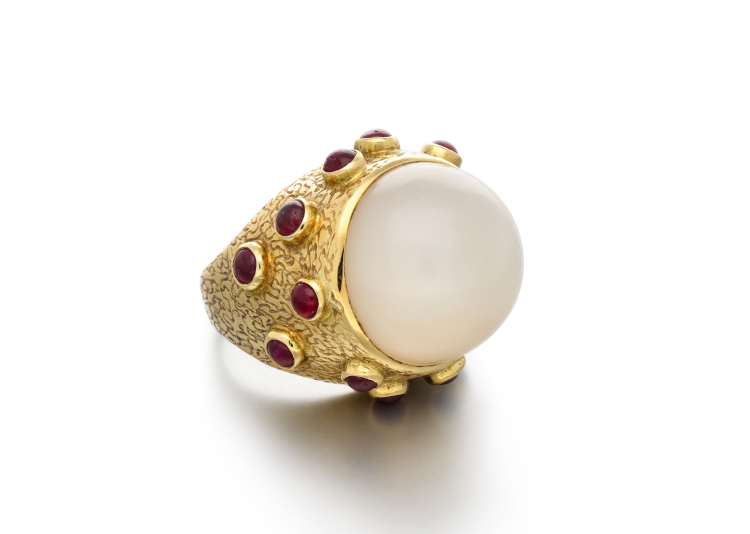 В центре этого кольца из 18-каратного золота, изготовленного в 1969 году, находится гладкий кабошон из халцедона. На полосу кольца нанесена гравировка, образующая абстрактный узор, и она украшена более мелкими рубинами-кабошонами.  (Сотбис)