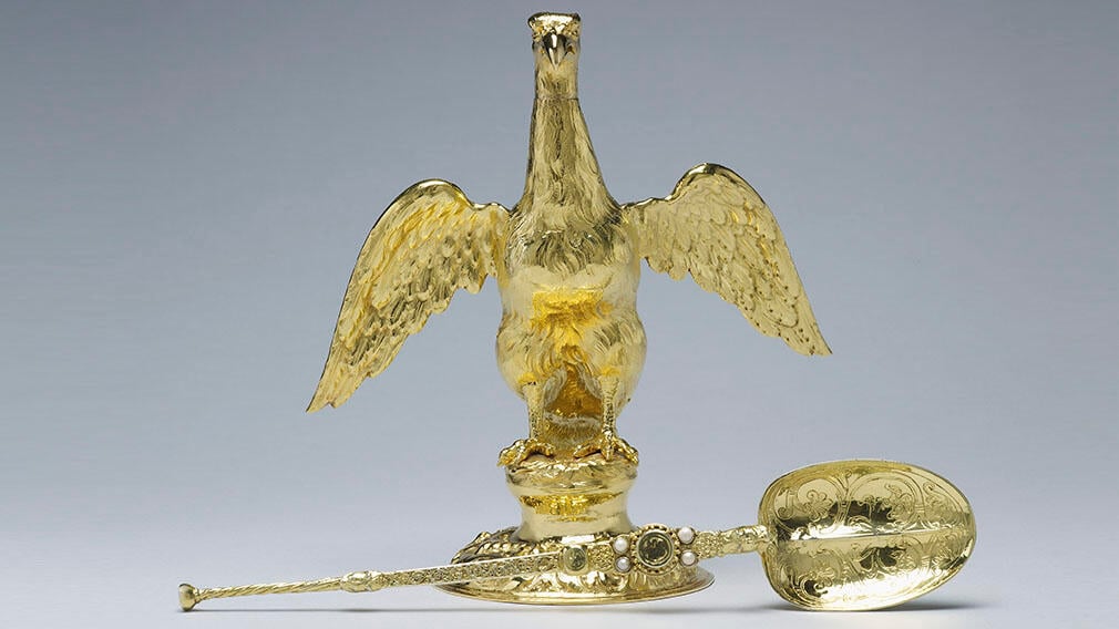Золотая фляжка в форме орла и большая золотая ложка с жемчугом и выгравированными завитками.