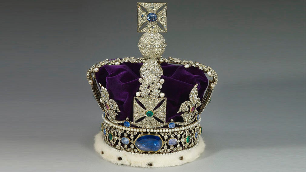 Корона с тысячами бриллиантов, пурпурный бархатный колпачок и крупный сапфир в центре.