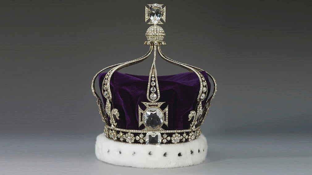 Серебряная корона с тысячами бриллиантов и фиолетовая бархатная шапочка.