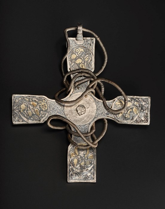 Серебряный крест с золотыми деталями на плечах и спиральной цепью вокруг центра на черном фоне.