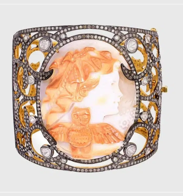 Два примера современных камей из ракушек включают браслет-манжету в золотой, серебряной оправе с бриллиантами и подвеску в виде резного черепа, обвитую инкрустированной бриллиантами золотой змеей.