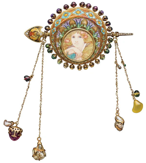 Французское украшение для корсажа в стиле ар-нуво из жёлтого золота, украшенное эмалью, жемчугом и драгоценными камнями. Диск, изготовленный Жоржем Фуке по эскизу Альфонса Мухи, украшен девичьей головкой и женской фигурой с пером, написанными Мухой на веленевой бумаге (телячьей коже). На четырёх цепях подвешены различные драгоценности. Около 1900 года, Франция.